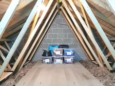 an attic with wooden beams and boxes on the floor