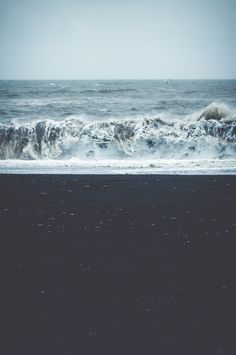 an ocean view with waves crashing on the shore