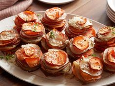 a white plate topped with lots of food on top of a wooden table next to plates