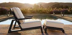 two lounge chairs sitting next to a swimming pool