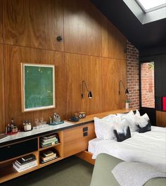 a bedroom with wood paneling and white bedding