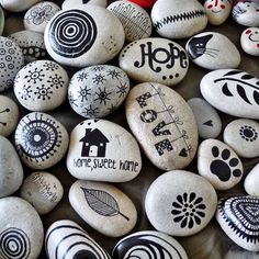 some rocks with different designs on them and words painted on them, all in black and white