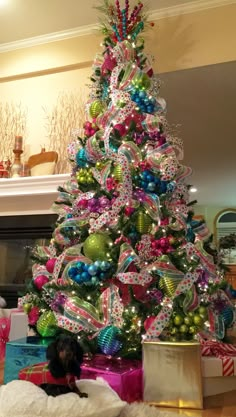 a brightly colored christmas tree with presents under it