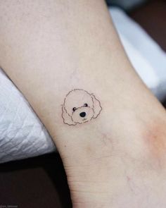 a small dog's head on the ankle is drawn in black ink with a tiny outline