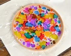 there is a cake covered in colorful confetti on top of plastic wrapper