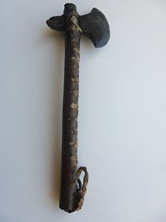 an old hammer and rope hanging on the wall