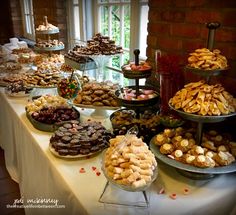 a table filled with lots of desserts and pastries on top of it's sides