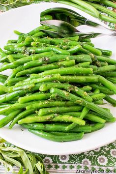 a white plate topped with green beans covered in seasoning