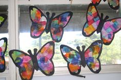 colorful paper butterflies hanging from a window sill