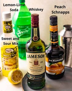 three bottles of liquor sitting on top of a counter next to lemons and other drinks