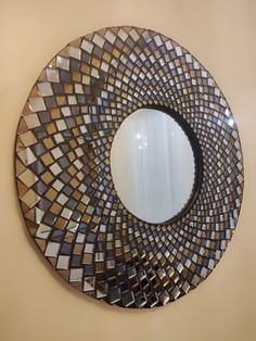 a mirror that is on the wall with some kind of design in it's center