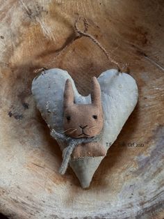 a small stuffed animal is hanging on a tree stump in the shape of a heart