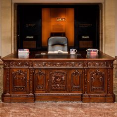 an office desk with a chair and books on it