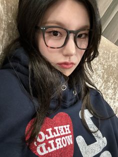 a woman wearing glasses and a hoodie with the word hello world written on it