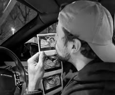 a man sitting in the driver's seat of a car looking at an x - ray