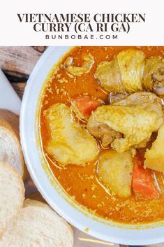 a white bowl filled with soup next to bread on top of a wooden table,