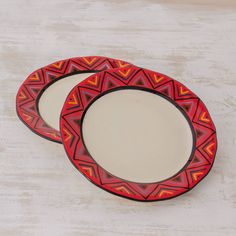 two red and black plates sitting next to each other