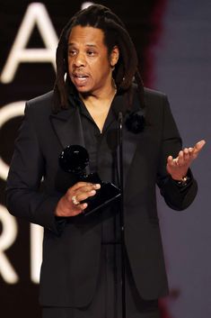 a woman standing in front of a microphone and holding an award for best performance at the oscars