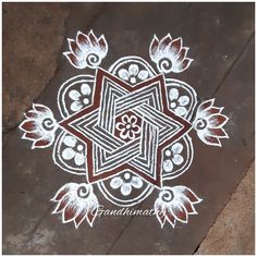 an intricate design on the ground in white and brown colors with leaves, flowers and dots