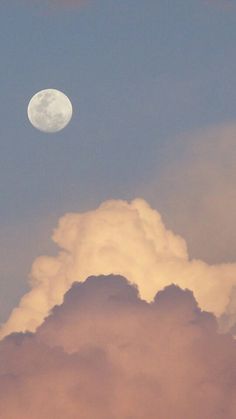 an airplane flying in the sky with a full moon behind it and some clouds below