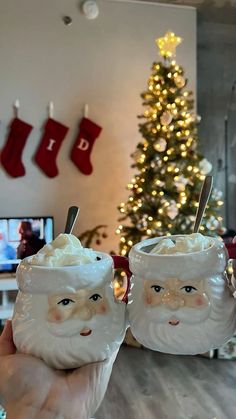 two cups with whipped cream in front of a christmas tree