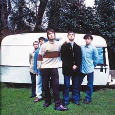 a group of young men standing in front of a camper