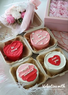 four valentine's day cupcakes in pink and white cases