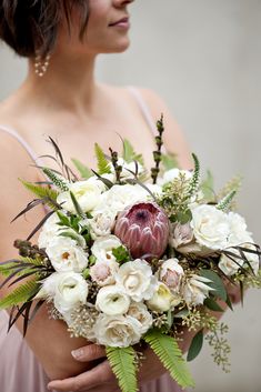 a woman holding a bouquet of flowers in her hands