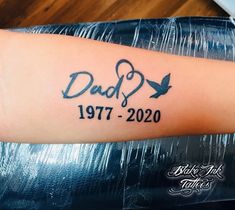 a tattoo that says dad and two birds on the side of a person's arm