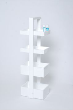 a white shelving unit with three shelves on each side and one shelf holding two bottles