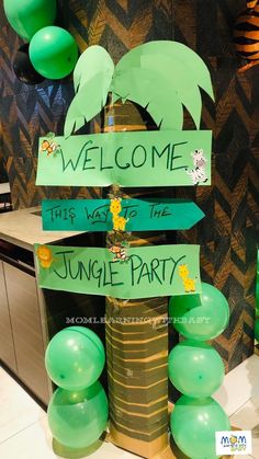 a welcome sign with green balloons and streamers