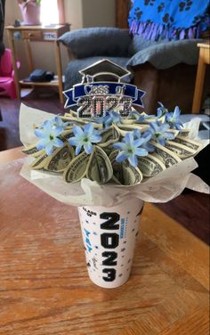 a cup with money in it sitting on top of a table