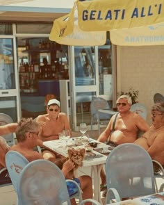 four men and two women sitting at an outdoor table