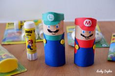 some toilet paper rolls are sitting on a table with other crafts and toys around them