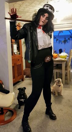 a woman dressed up as michael jackson in a living room with her dog and cat