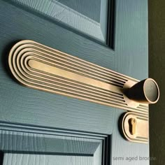 a close up of a door handle on a blue door with wood grained panels