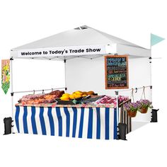 a white tent with blue and white striped table cloth on the side, displaying fresh produce