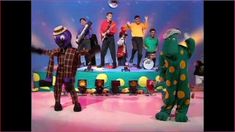 a group of people standing on top of a stage with one person in a costume