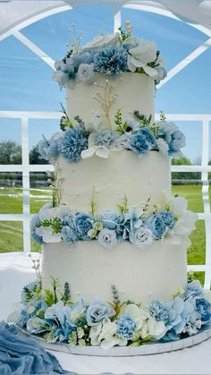 a wedding cake with blue and white flowers on it