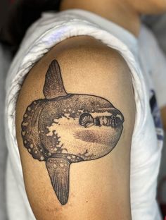 a man's arm with a shark tattoo on it