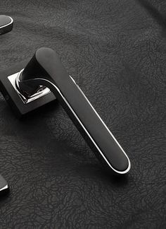 two black handles are sitting on a leather surface with one handle pointing towards the other