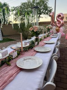 a table set up with plates and balloons