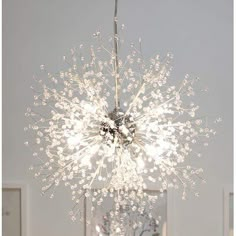 a chandelier hanging from the ceiling in a room with white walls and flooring