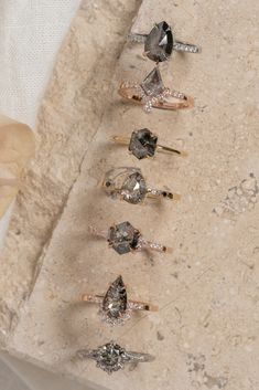 five different types of rings sitting on top of a stone slab