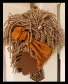 a woman's head with dreadlocks hanging on a door