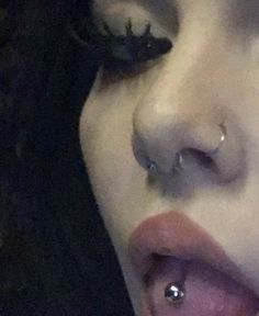 a close up of a woman's nose with piercings