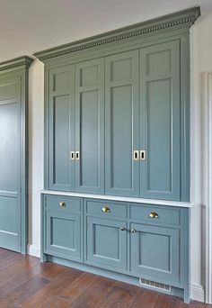 an empty room with blue cabinets and wood floors