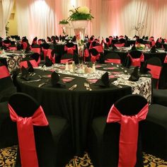 a banquet room set up with black and red linens