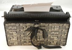 an old fashioned suitcase with some writing on the lid and ribbon tied around the handle