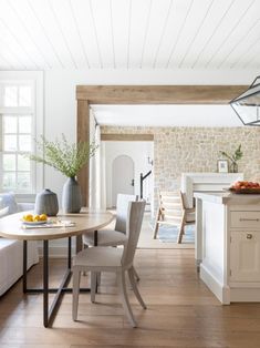 a kitchen and living room with white walls, wood flooring and exposed beams in the ceiling